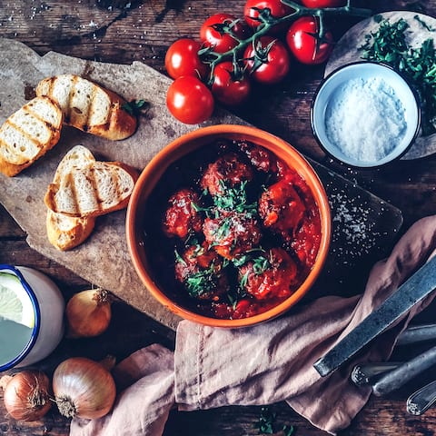 Spanische Tapas für zuhause: Lecker würzige Albondigas in köstlicher Tomatensoße – dazu passt Baguette. 