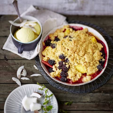 Fruchtiges Ananas-Brombeer-Crumble mit Vanilleeis und gerösteten Kokosnussspalten. Unser karibisches Dessert für den Sommer!