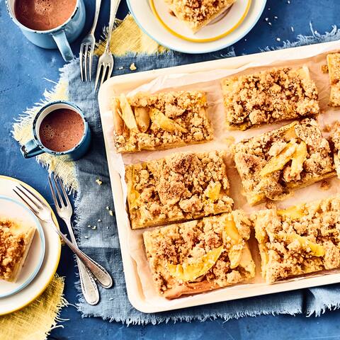 Fruchtig und süß: Unser Rezept für einen Hefeteig-Kuchen belegt mit Apfel, Mango, Crème fraîche und Kokosstreuseln – probieren Sie es gleich mal aus!