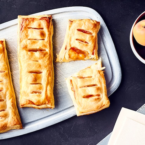 Ein köstliches Süßgebäck und ganz einfach selbergemacht: Blätterteigröllchen mit Aprikosen und Sommerfruchtfüllung. Dazu frische Schlagsahne. 