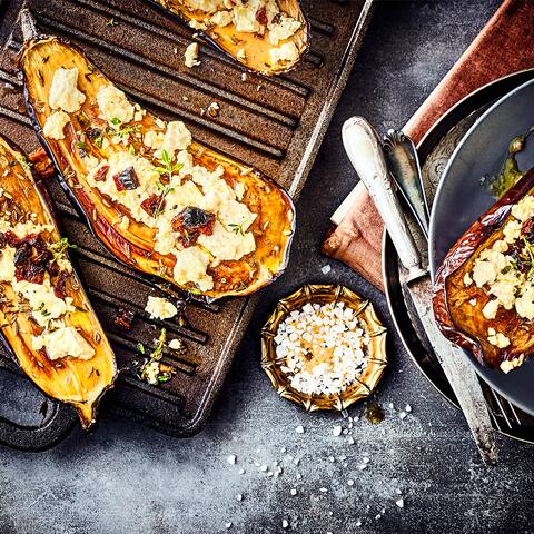Unser Rezept für gefüllte Aubergine mit Ziegenkäse, Knoblauch-Tomaten-Öl und frischen Kräutern ist vegetarisch und lecker – gleich ausprobieren!