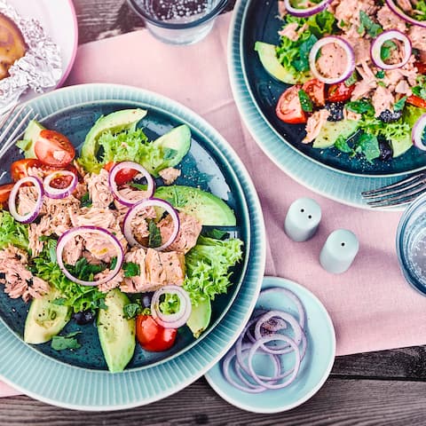 Mit unserem Rezept zaubern Sie in nur 10 Minuten einen laktosefreien Avocadosalat mit Thunfisch, roten Zwiebeln und Oliven auf den Tisch – gleich ausprobieren!