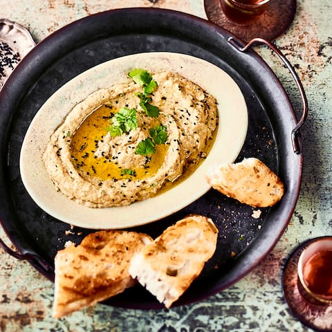 Auch bekannt als Auberginencreme oder Auberginenpaste ist Baba Ganoush ein Rezept der orientalischen Küche aus Auberginen, Knoblauch, Koriander und Tahin.