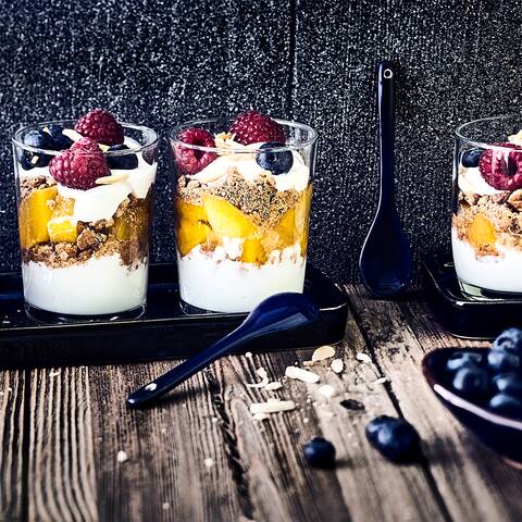 Leckere Nachspeise in nur 30 Minuten: Probieren Sie unser Schicht-Dessert mit frischen Beeren, Pfirischen, Joghurt und Vollkorn-Haferkeksen!