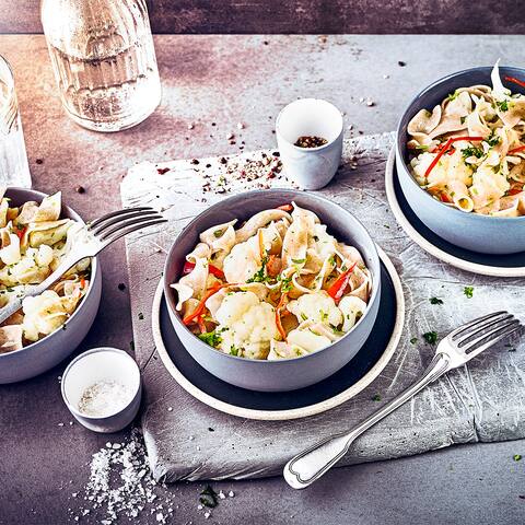 Fein geschnittener Knoblauch, Petersilie und gedünstete Zwiebeln verleihen unseren Vollkornnudeln mit Blumenkohl und Chili zusätzlich eine würzig Note. 