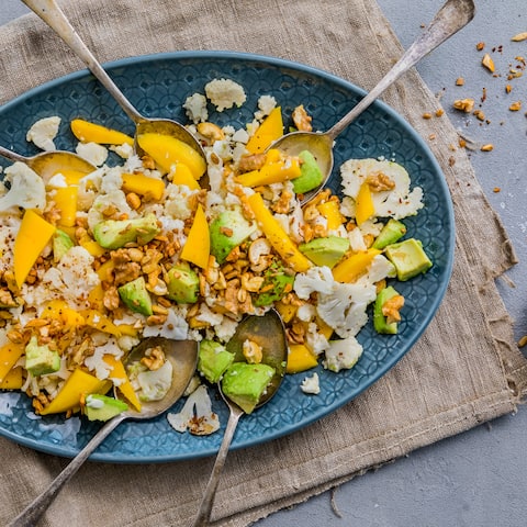 Blumenkohl ist ganz schön vielseitig, und darum machen wir daraus diesen leckeren Blumenkohl-Salat mit Mango, Avocado und einem Nuss-Topping.