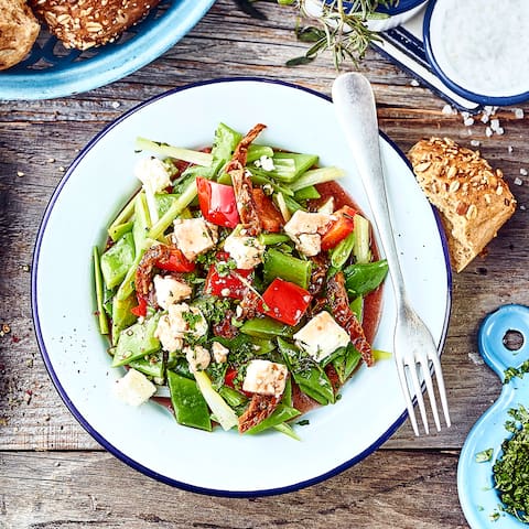 Vegetarisches Gericht aus der mediterranen Küche: Genießen Sie unseren Salat mit Stangenbohnen und Paprika, getrockneten Tomaten, Knoblauch und Schafskäse.