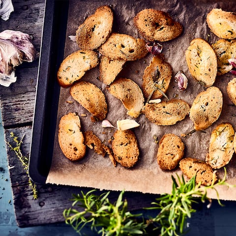 Ideal als kleiner Snack vor der Vorspeise oder als Chips-Ersatz zum Knabbern: Selbstgemachte Brotchips mit frischen Kräutern und Knoblauch. 