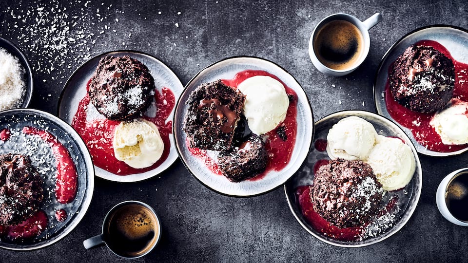 Servieren Sie Ihren Gästen unsere Brownie-Muffins mit Zartbitterschokolade, Bananen & Kardamom an einer fruchtigen Soße aus frischen Himbeeren als Dessert!