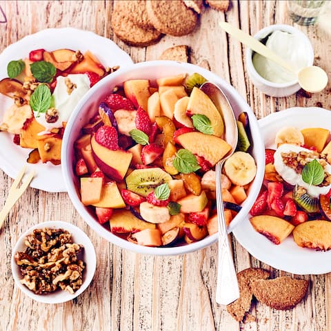 Probieren Sie unseren bunten Obstsalat: Mit exotischen Früchten, karamellisierten Walnüssen und frischer Quarkcreme mit Honig und Ingwer!