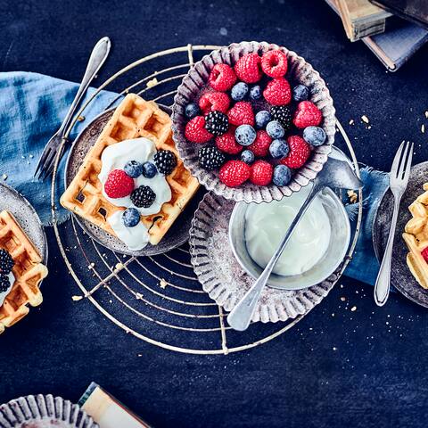 Da läuft einem glatt das Wasser im Mund zusammen! Die Buttermilchwaffeln sind besonders fluffig und werden mit selbstgemachter Vanille-Quark-Creme und ganz viel frischem Obst serviert!
