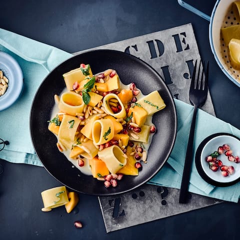 Italienische Calamarata mit Mango, Pinienkernen und Minze. Mit Kokosmilch bekommen die dicken Nudeln einen leicht orientalischen Geschmack und die Soße wird herrlich cremig. 