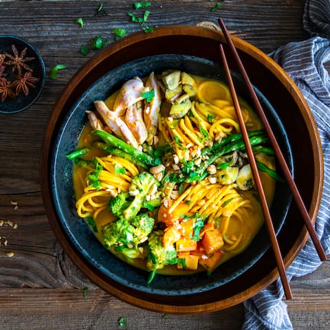 Alles aus einer Schüssel: In unserer Curry-Nudel-Bowln finden Sie Nudeln mit Hähnchenbrust, Brokkoli, Pilzen, Kürbis und Koriander in einer cremigen Erdnuss-Kokos-Sauce. 