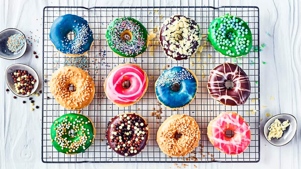 Unser Tipp für die nächste Geburtstags-Party: Probieren Sie dieses Rezept aus und präsentieren Sie selbstgemachte Donuts aus Milch-Hefeteig mit bunter Glasur, hier dürfen Sie sich kreativ austoben!