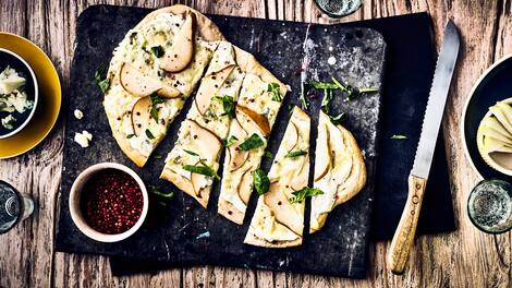 Backen Sie einen herzhaften Hefeteig und belegen Sie ihn mit frischen Birnen, Zitrone, Frischkäse oder Gorgonzola für einen leckeren Flammkuchen.