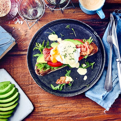 Ei mal anders: Genießen Sie mit unserem Eggs Benedict Rezept Avocado, Salat, Tomatenscheiben, Bacon, Sauce Hollandaise und pochierte Eier auf gerösteten Brotscheiben. 