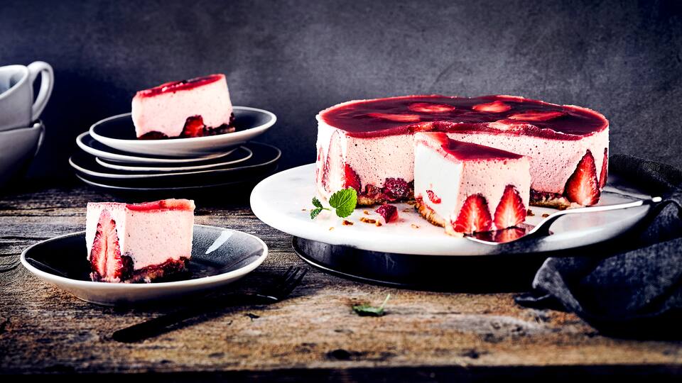 Unser Tipp für Ihre sommerliche Kaffeetafel: Probieren Sie unsere fruchtige Torte mit Biskuitboden und zarter Mousse aus frischen Erdbeeren und Sahne!