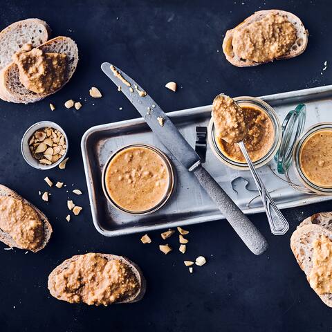 Selbst gemachte Erdnussbutter mit gerösteten Erdnüssen zum Frühstück auf einem knackigen Baguette – wer kann da schon wiederstehen?!
