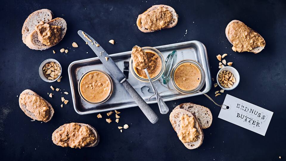 Selbst gemachte Erdnussbutter mit gerösteten Erdnüssen zum Frühstück auf einem knackigen Baguette – wer kann da schon wiederstehen?!