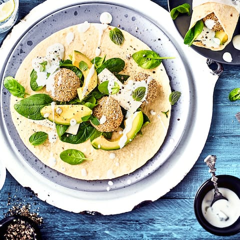 Gesunde vegetarische Wraps mit Avocado, Feta, Babyspinat und selbstgemachten Falafeln. 