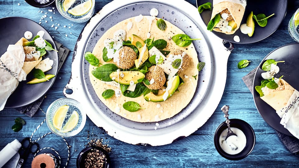 Gesunde vegetarische Wraps mit Avocado, Feta, Babyspinat und selbstgemachten Falafeln. 