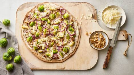 Kochen Sie unser Rezept für Flammkuchen mit Rosenkohl in 40 Minuten nach & servieren Sie Ihren Gästen feines Gemüse mit Walnüssen auf knusprigem Dinkelteig.