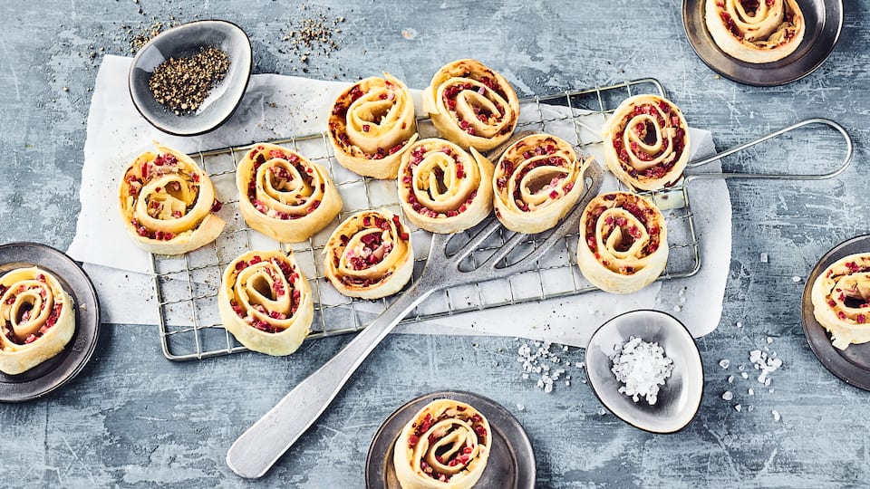 Pizzaschnecke mal anders: Auch Flammkuchen-Schnecken sind eine super Idee für ein kleines Buffet und schmecken herrlich knusprig.