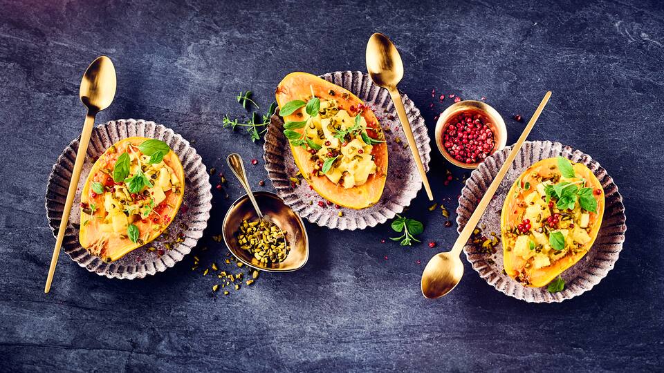 Probieren Sie dieses exklusive Dessert einmal für Gäste aus: Gebackene Papaya gefüllt mit Kokosmilch-Ananas-Mischung und gehackten Pistazien! 