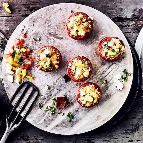 Grillen Sie in nur 30 Minuten vegetarisch gefüllte Tomaten mit Couscous und würzigem Fetakäse – mit Kreuzkümmel und frisch gepresster Zitrone abgeschmeckt. 