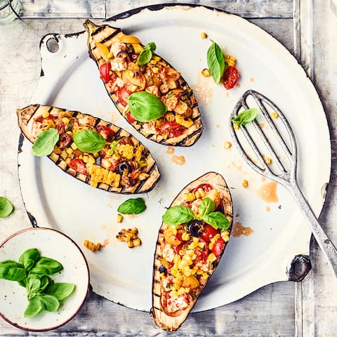 Als Beilage fast zu schade, denn dieses Rezept kann es mit jedem Hauptgericht aufnehmen: Gegrillte Auberginen, gefüllt mit Mais, Tomaten, Feta und schwarzen Oliven.