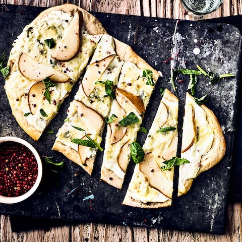 Backen Sie einen herzhaften Hefeteig und belegen Sie ihn mit frischen Birnen, Zitrone, Frischkäse oder Gorgonzola für einen leckeren Flammkuchen.