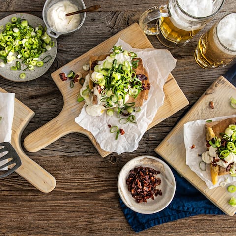 Genießen Sie deftiges Handbrot mit Käse, Speck, Zwiebeln und Crème fraîche! Mit unserem Rezept sind die würzigen Fladen schnell und einfach zubereitet.