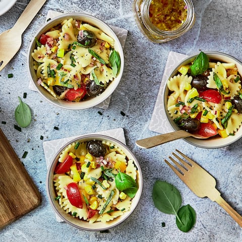 Unser mediterraner Nudelsalat mit Tomaten, Paprika, Mais und Oliven bringt die intensiven Aromen der Mittelmeerküche auf Ihren Teller.