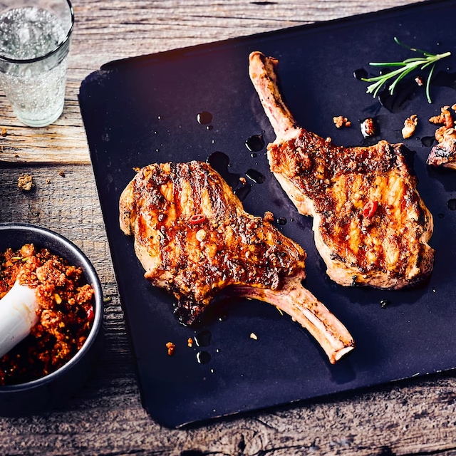 Saftiges Iberico-Kotelett vom Grill mit einem fruchtigen Rub mit Orange, Haselnüssen, Rosmarin und Knoblauch. Das Fleisch ist herrlich saftig und die Kruste schön kross.