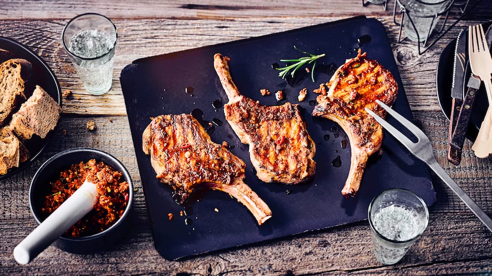 Saftiges Iberico-Kotelett vom Grill mit einem fruchtigen Rub mit Orange, Haselnüssen, Rosmarin und Knoblauch. Das Fleisch ist herrlich saftig und die Kruste schön kross.