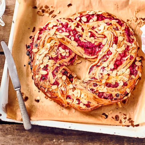 Ein Glanz auf der Kaffetafel: Köstlicher geflochtener Hefekranz mit einer fruchtigen Marzpian-Johannisbeerfüllung.