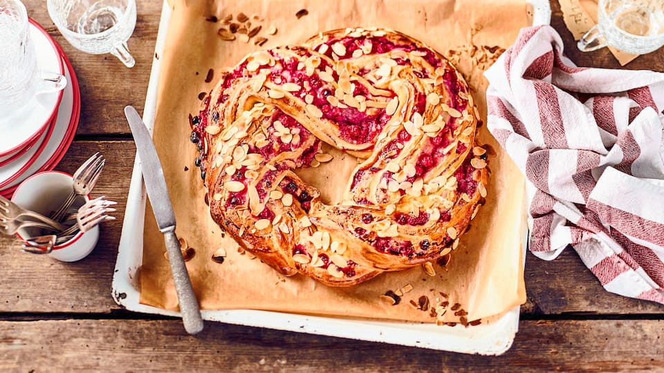 Ein Glanz auf der Kaffetafel: Köstlicher geflochtener Hefekranz mit einer fruchtigen Marzpian-Johannisbeerfüllung.