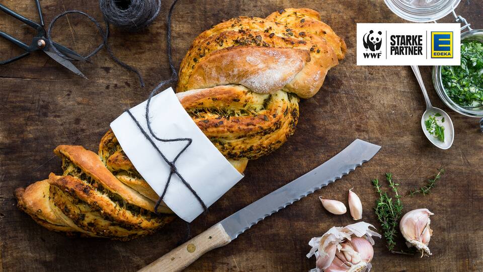 Selbstgebackenes Knoblauchbaguette mit Kräuterpesto und Parmesan passt perfekt zum Grillabend. 