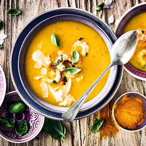 Raffinierte Vorspeise für Ihr Wintermenü oder einfach als warme Suppe an kalten Tagen: Probieren Sie unser Süppchen aus Kürbis, Kaki und Ingwer mit angebratenen Garnelen und Kokosraspeln! 