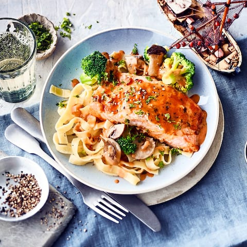 Exquisite Kombination für Fisch-Liebhaber: Probieren Sie unser überbackenes Lachsfilet mit Brokkoli-Pilz-Gemüse in Weißwein-Käse-Soße und Tagliatelle!