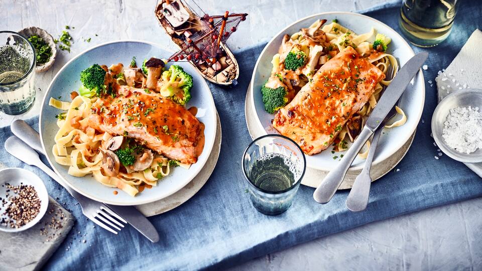 Exquisite Kombination für Fisch-Liebhaber: Probieren Sie unser überbackenes Lachsfilet mit Brokkoli-Pilz-Gemüse in Weißwein-Käse-Soße und Tagliatelle!