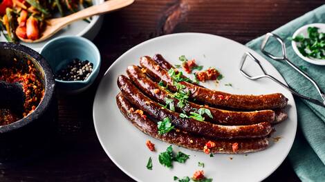 Deftiges für den Grill: Probieren Sie unsere Lammwürstchen mit Harissa, einer scharfen Gewürzpaste aus Chili, Kümmel, Curry und frischen Kräutern!