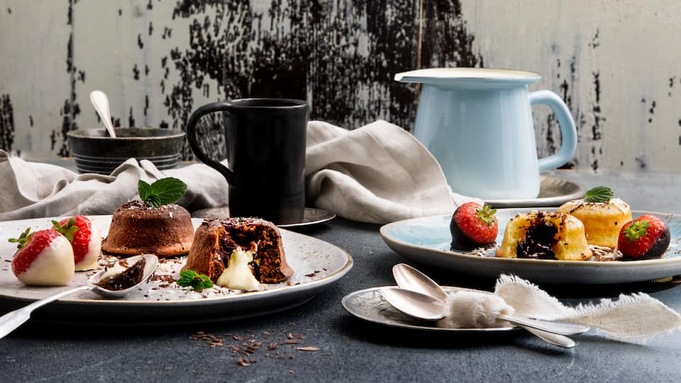 Gibt es etwas Köstlicheres als Lava-Cake mit flüssigem Kern? Ja: Zwei Varianten davon! Probieren Sie unser Rezept für hellen und dunklen Lava-Cake und servieren Erdbeeren dazu. 