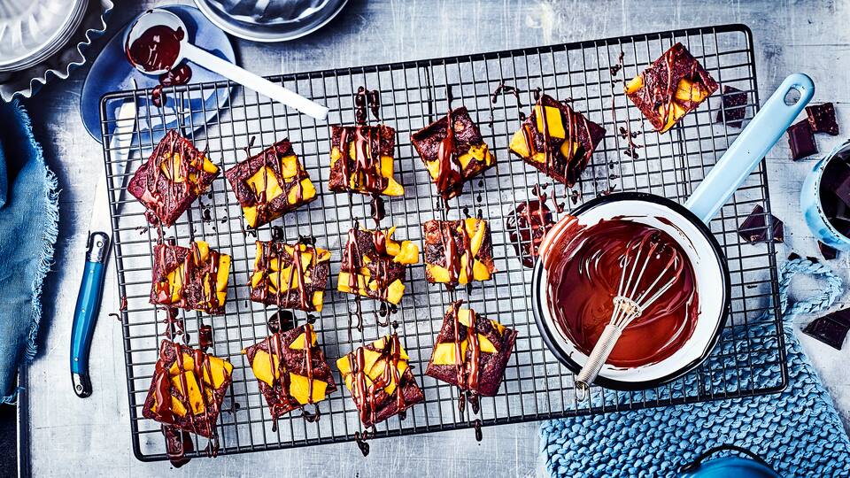 Exotisches Brownie-Dessert mit Früchten: Probieren Sie unsere Brownies mit frischer Mango, Banane, Datteln und gehackten Walnüssen – lecker und laktosefrei!