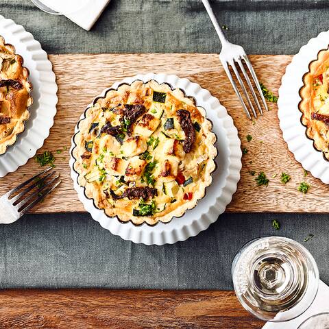 Mediterraner Snack für zuhause: Kleine selbstgemachte Mürbeteig-Törtchen mit allerlei mediterranem Gemüse und Feta.