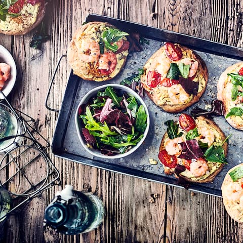 Warum Pizza immer nur aus dem Ofen? Im Sommer schmeißen wir doch viel lieber den Grill an: Genießen Sie unsere kleinen Mini-Salatpizzen mit Garnelen, Tomaten und Rucola!