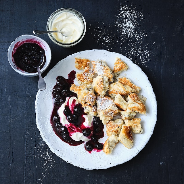 Die beliebte Mehlspeise lässt sich vielseitig versüßen - wir verfeinern unseren Kaiserschmarrn mit Mohn und servieren ihn mit Heidelbeeren und Crème fraîche.