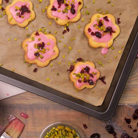 Backen Sie unsere fruchtigen Kekse aus Mürbeteig! Getrocknete Cranberrys, Cranberrysaft und gehackte Pistazien geben den Plätzchen ihren süß-säuerlichen Geschmack – perfekt für Geburtstage und Partys. 