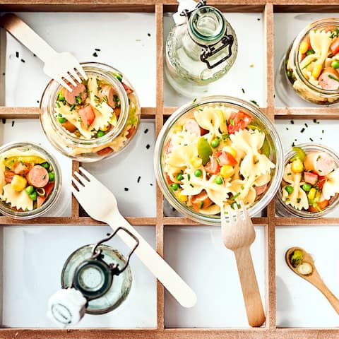 Wurst im Nudelsalat ist ein Klassiker - Probieren Sie doch mal unseren Nudelsalat mit Wiener: aus Paprikaschoten, Tomaten, Erbsen und Mais.