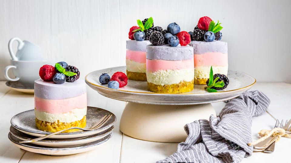 Kleine Minitorten für einen besonderen Anlass: Unser Rezept für Ombré-Beeren-Cremetörtchen zeigt Ihnen wie Sie aus einem knusprigen Müsli-Boden, sahniger Creme und zweierlei Beerencreme die kleinen Törtchen herstellen.